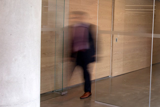 Photo of Blurry man walking out of glass doors