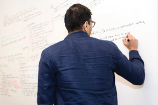 Photo of a student writing on a white board