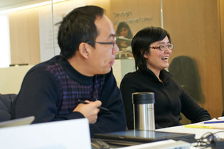 A photo of 2 PhD students laughing during a class